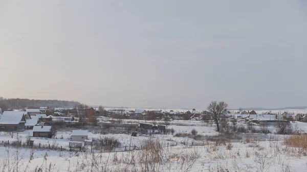 Vista del tipico villaggio russo in inverno - giornata fredda nel campo innevato — Foto Stock