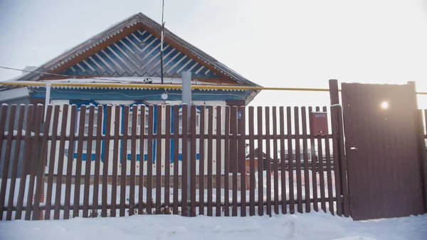 País ruso - casa de campo típica en un pueblo vacío cubierto de nieve en el día soleado — Foto de Stock