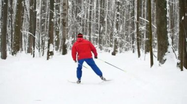 Kış spor - kayakçı Kırmızı elbiseli kar ormanda slaytlar