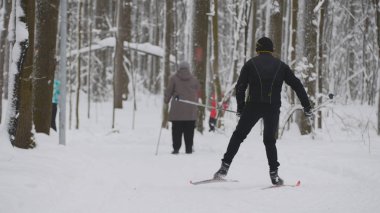 Siyah ceketli adam kayakçı kış kar ormanda slaytlar