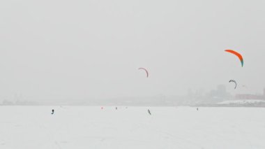 Kış extremal spor - kar-uçurtma sportsmens çoğunu blizzard bulutlu gün buz Nehri üzerinde sürmek