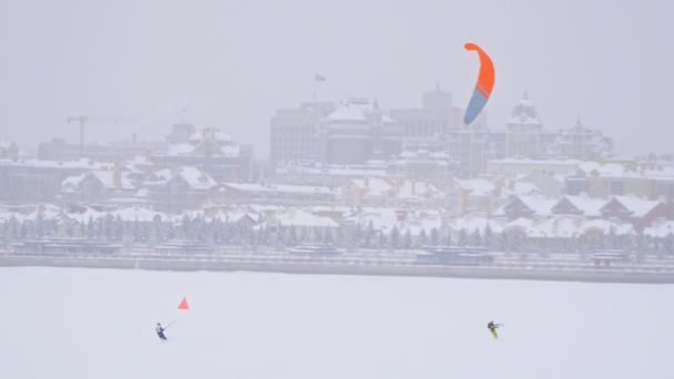 Oranžové sněhu draci na ledu river - zimní extremální sport na blizzard — Stock video