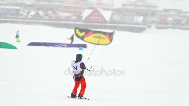 Kazan, Russia, 7 january 2017, Snow-kite sportsmen in red suit rides on the ice river - winter extremal sport at blizzard — Stock Video