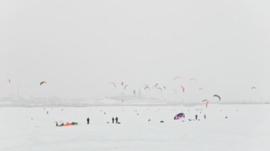 Kış extremal spor - renkli kar-uçurtma buz Nehri şehir blizzard bulutlu gün, önünde bir sürü