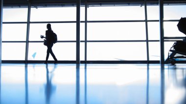 Sırt çantası gözlük Havaalanı pist, karşısında pencerenin önünde gidiyor kızla siluet