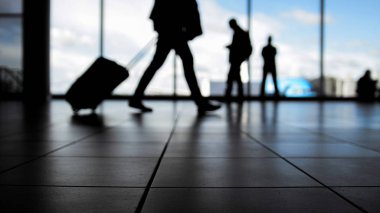 Gezginler Havaalanı gidiş için pencerenin, önünde yürüyen merdiven tarafından yürüyüş ile siluet