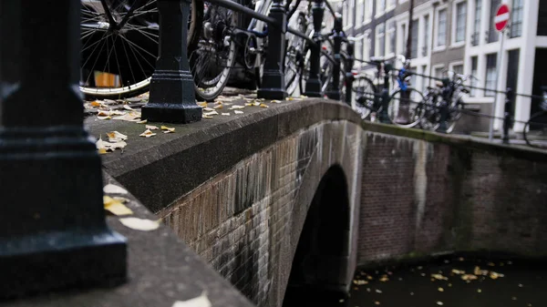 Амстердамский канал, раннее утро, пасмурный день, Автумн, детали - мост, велосипеды, туристы — стоковое фото
