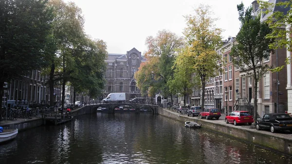 Амстердам утром в центре города - улица с велосипедами и автомобилями на канале, Автумн, Нидерланды — стоковое фото