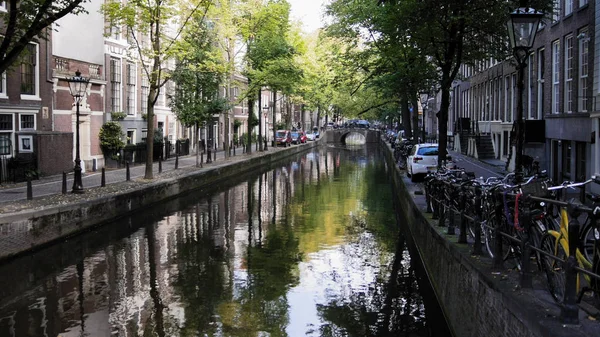 Амстердам утром в центре города - улица с велосипедами и автомобилями на канале, Автумн, Нидерланды — стоковое фото