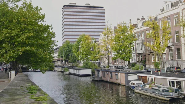 Aken en woonboten aan de gracht van de Amstel in Amsterdam, Nederland — Stockfoto