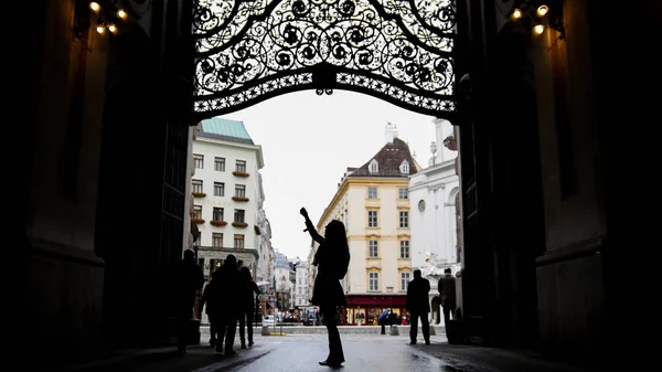 Vrouw met behulp van de mobiele telefoon in de hofburg Vienna, silhouet, groothoek — Stockfoto