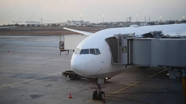 L'avion est près du terminal de l'aéroport international au crépuscule — Photo