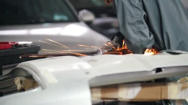 Servicio de coche profesional - trabajador de metal de molienda con una sierra circular, vista trasera — Vídeos de Stock