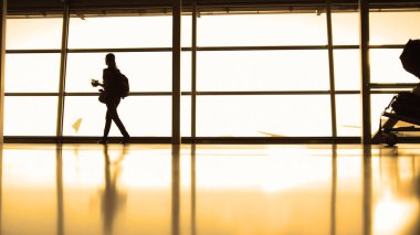 Gidiş Havaalanı pist, sıcak, karşısında pencerenin önünde siluet sırt çantası gözlük ile kız