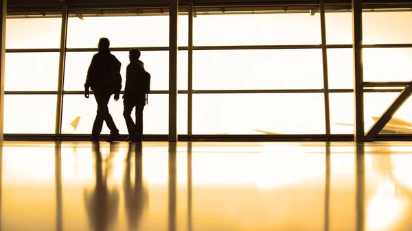 Utasok előtt ablak airport, silhouette, meleg — Stock Fotó