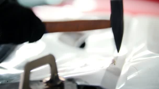 Автосервис - рабочий обрабатывает детали кузова автомобиля с помощью хаммера — стоковое видео