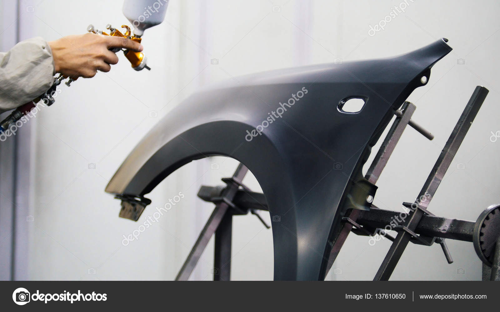 Professional car painter is painting in garage by airbrush Stock Photo