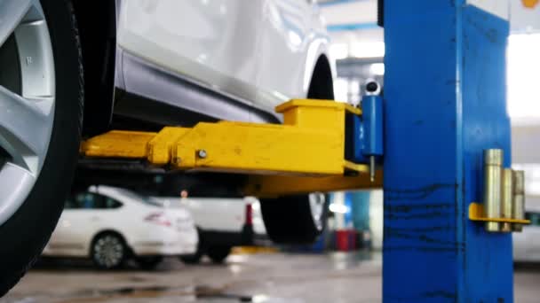 Auto im Autoservice Hebebühne zur Reparatur, Mechanik in der Garage — Stockvideo