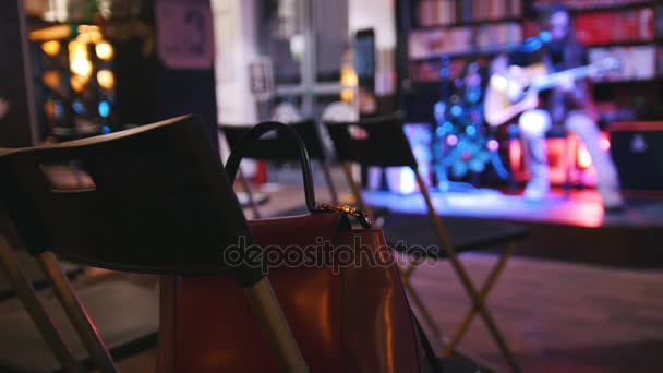 La borsa è sulla sedia - stanza vuota davanti al chitarrista al concerto - chitarra acustica, microfono, club — Video Stock