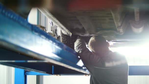 Servicio de automóvil - dispositivo de trabajo de envoltura mecánica debajo de la parte inferior del coche — Vídeos de Stock
