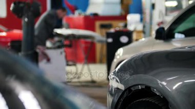 De-odaklı endüstriyel arka plan - araç teşhis ve tamir servisi - adam iş tenekeci çalışır bir çekiç ile