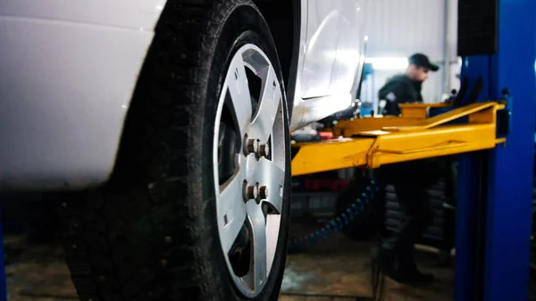 Coche en auto servicio de elevación para la reparación, mecánica en el garaje —  Fotos de Stock