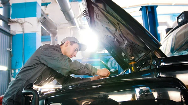 Mecánico en servicio de coche - reparación en el compartimiento del motor para SUV de lujo — Foto de Stock