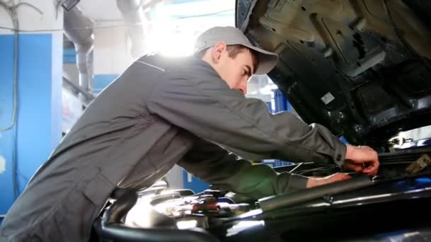Mecánico en overoles trabajando en el garaje - reparación de SUV de lujo frente al sol — Vídeo de stock