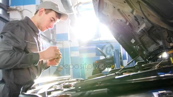 Mecánico trabajando en el garaje - reparación de SUV de lujo frente al sol — Vídeo de stock