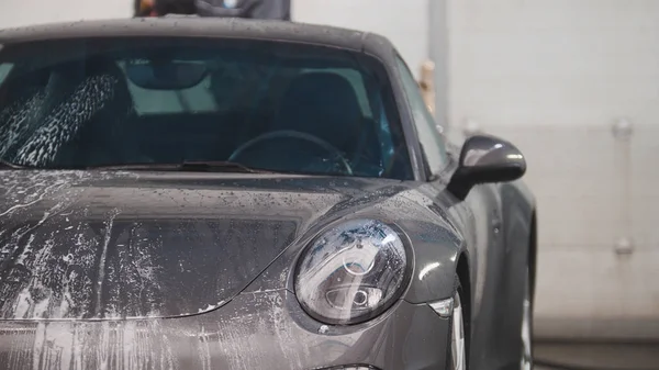 Automobil waschen - Sportwagen im Sud durch Wasserschläuche — Stockfoto