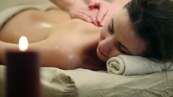 Massagesalon - junges Mädchen bekommt entspannende Heiltherapie für den Rücken — Stockvideo