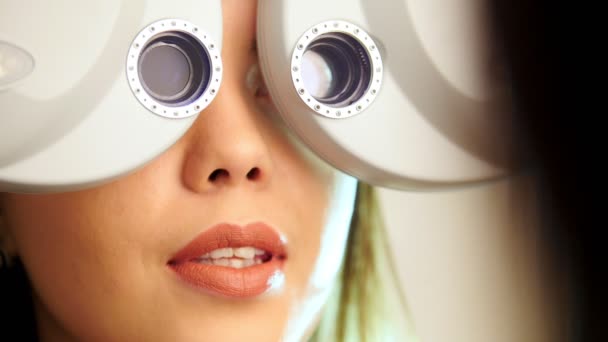 眼科诊所-女人通过现代设备-左眼检查视力 — 图库视频影像