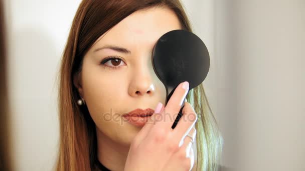 Oftalmologi medicinsk, hälsa, koncept - vacker flicka kontroller vision i en ögonläkare med ena ögat stängt — Stockvideo