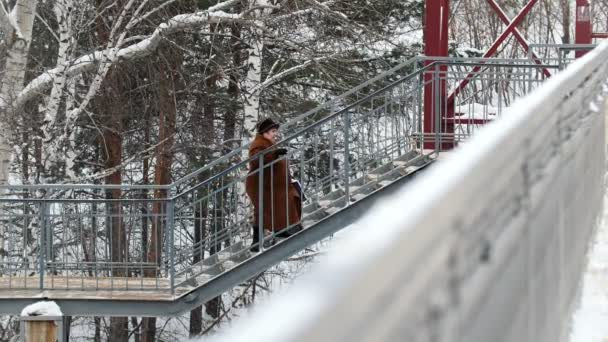 Kazan, Rusia, 14 de febrero de 2017, mujer malsana gorda mayor que se muda arriba en las estaciones de tren en el día de invierno — Vídeo de stock