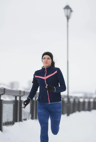 Fitness dziewczyny modelu działa na śniegu zimą promenady, jogging — Zdjęcie stockowe