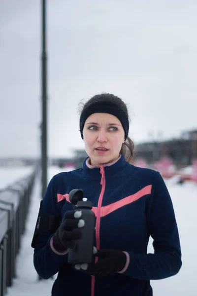 Sport Fitness tjej dricker vatten på jogging utanför på molnig vinterdag — Stockfoto