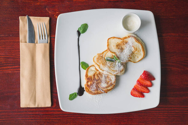 Fritters of cottage cheese. Hot pancake with strawberry and sauce