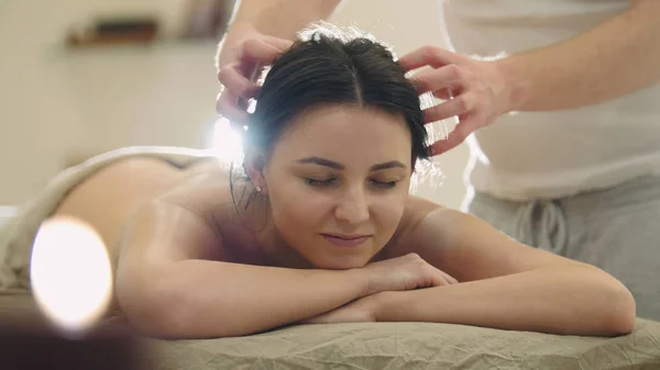 Salão de massagem - jovem mulher recebe terapia de cura relaxante para a cabeça e cabelo — Fotografia de Stock