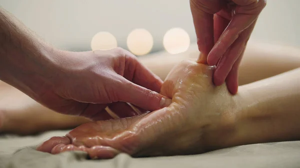 Massagem de óleo para calcanhar na perna. Tratamento de relaxamento para mulheres jovens, close-up — Fotografia de Stock