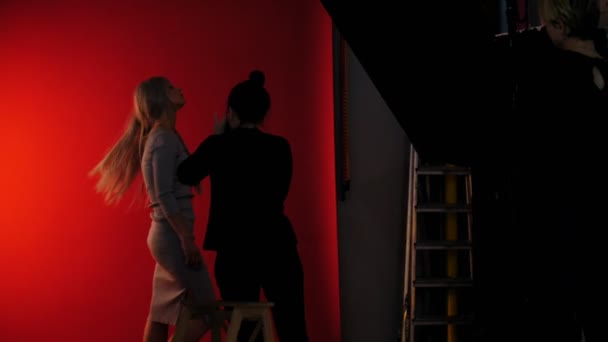 Backstage: fotosessie in studio met meisje model - speelt lang blond haar — Stockvideo