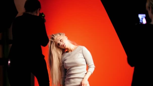 Mode backstage: Blondes Model spielt lange Haare - Fotograf fotografiert im Studio, Visagistin mit Smartphone — Stockvideo