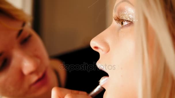 Салон красоты: визажист создает макияж для губ привлекательной молодой женщины, телефото — стоковое видео