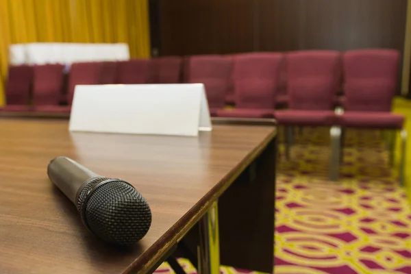 Мікрофон на столі в прес-конференц-залі або семінарській кімнаті фону — стокове фото