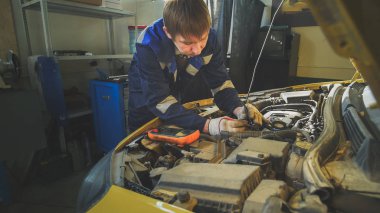 Tamirci elektrikli araba-motor bölmesi içinde tamir başlıklı denetler