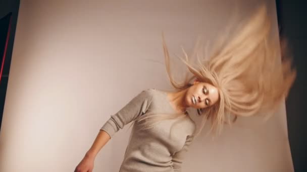Дівчина модель з рухомим волоссям у фотостудії, повільний рух — стокове відео