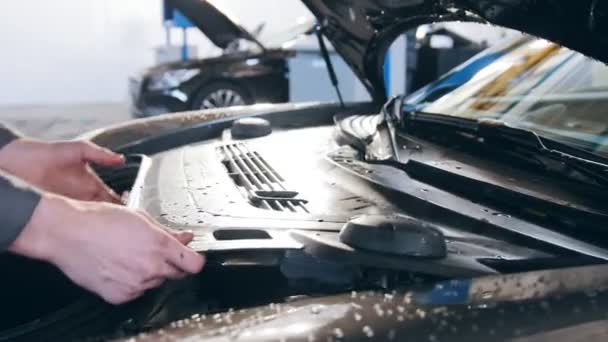 Mains de mécanicien dans le capot de contrôle de garage automobile pour la voiture de luxe — Video