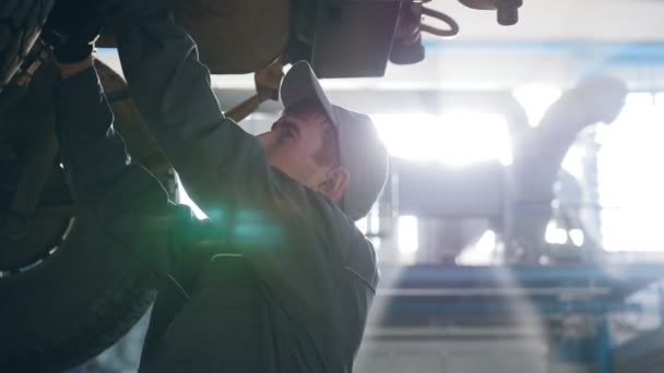 Внедорожник подняли в автосервисе на ремонт, рабочие крепят ограждения — стоковое видео