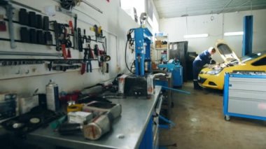 Küçük araç garaj - otomatik mekanik motor kaputunun sarı araba içinde denetler.