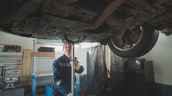 Mechanik w pracy - samochody dołu pod zniesione samochodu — Zdjęcie stockowe