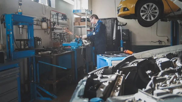 Χειρωνακτική εργασία μικρών επιχειρήσεων - συνεργείο - αρσενικό Καυκάσιος μηχανικός εργαζόμενος λειτουργεί με δισκοπρίονο — Φωτογραφία Αρχείου